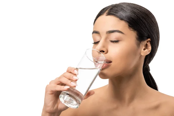 Attraktive junge afrikanisch-amerikanische Frau mit geschlossenen Augen trinkt Wasser aus Glas isoliert auf weiß — Stockfoto