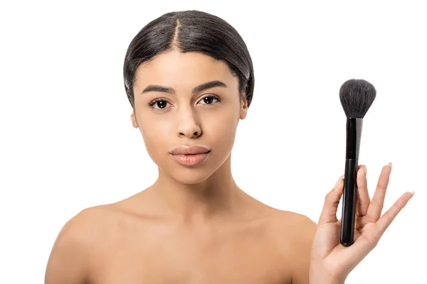 Belle femme africaine américaine nue tenant pinceau de maquillage et regardant la caméra isolée sur blanc — Photo de stock