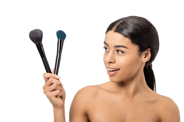 Heureux nu afro-américain fille tenant pinceaux de maquillage isolé sur blanc — Photo de stock