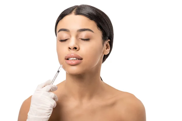 Young african american woman getting beauty injection in lips isolated on white — Stock Photo