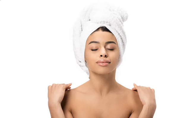 Relaxed naked african american woman with closed eyes and towel on head touching shoulders isolated on white — Stock Photo