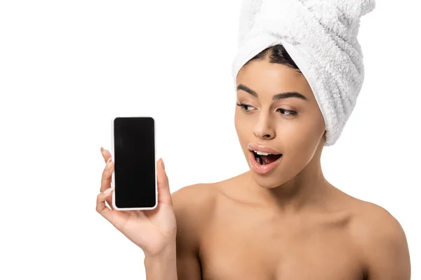 Shocked young african american woman with towel on head looking at smartphone with blank screen isolated on white — Stock Photo