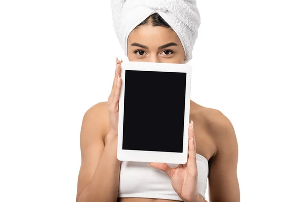 Attrayant afro-américain fille avec serviette sur la tête tenant tablette numérique avec écran noir et regardant la caméra isolée sur blanc — Photo de stock