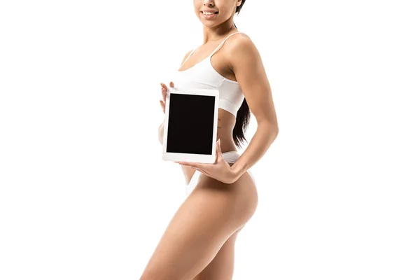 Ritagliato colpo di donna afroamericana sorridente in biancheria intima bianca con tablet digitale con schermo nero isolato su bianco — Foto stock
