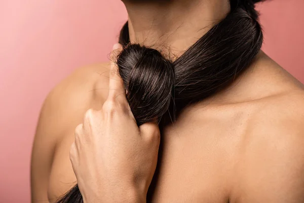 Abgeschnittene Aufnahme von nackten weiblichen Schultern und langen brünetten Haaren um den Hals isoliert auf rosa — Stockfoto