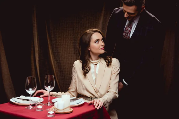 Belo casal olhando uns para os outros durante o jantar romântico no restaurante — Fotografia de Stock
