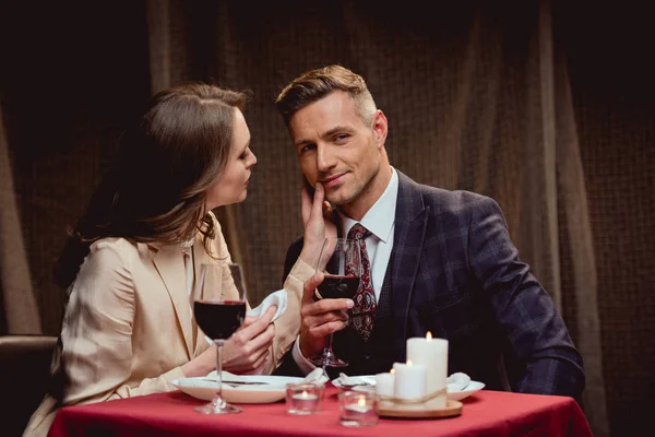 Woman touching face of handsome man during romantic date in restaurant — Stock Photo