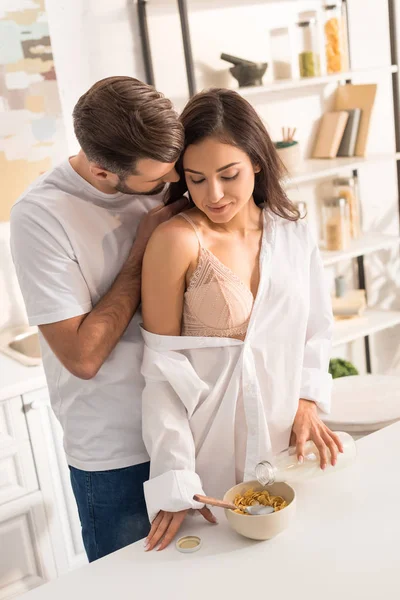 Homem abraçando mulher bonita durante o café da manhã em casa — Fotografia de Stock