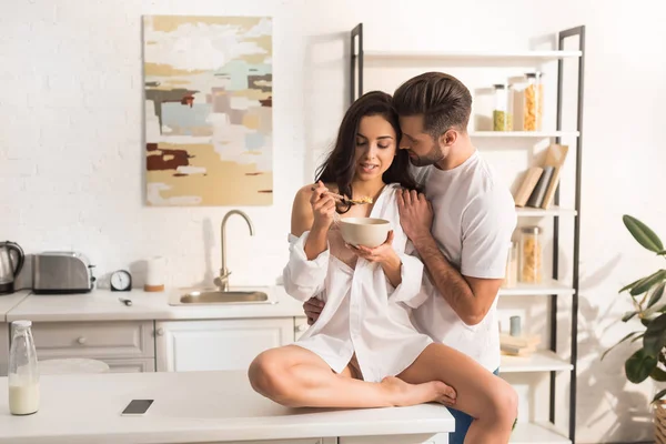 Uomo abbracciando bella donna durante la colazione in cucina — Foto stock