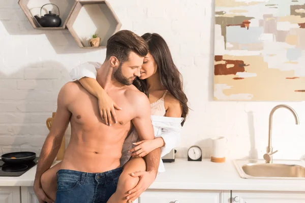 Selektiver Fokus eines schönen sexy Paares, das sich in der heimischen Küche umarmt — Stockfoto