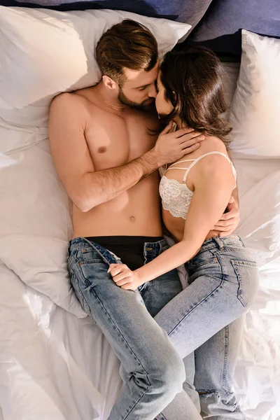 Beau couple sexy câlins et baisers dans le lit à la maison — Photo de stock