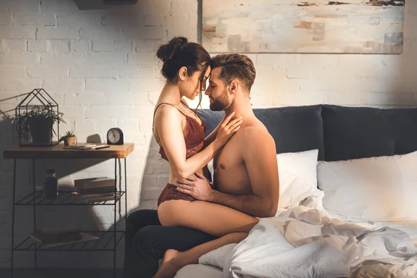 Bella coppia sexy che abbraccia sul letto a casa — Foto stock
