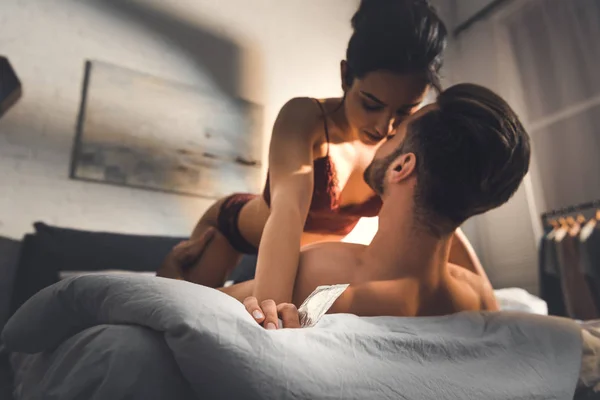 Selective focus of young sexy couple lying in bed during foreplay — Stock Photo