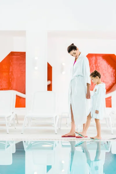 Happy mother holding hands with cute daughter near swimming pool — Stock Photo