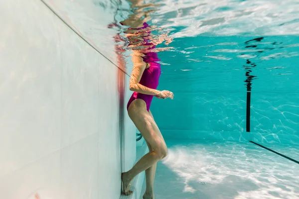 Обрізаний вид жінки під водою в купальнику у блакитній воді — стокове фото