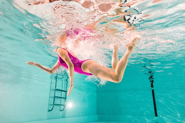 Vue dégagée femme plongée sous-marine en maillot de bain en piscine — Photo de stock