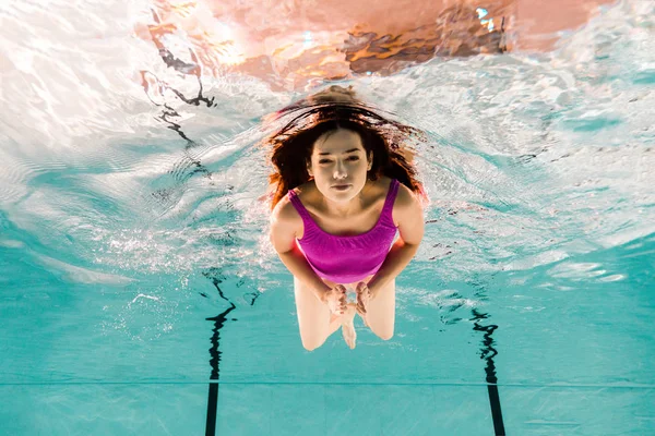 Schöne Frau taucht im Badeanzug im Schwimmbad unter Wasser — Stockfoto