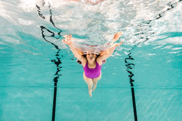 Woman swimming underwater in swimwear in blue water — Stock Photo