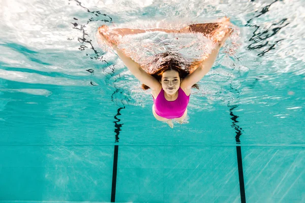 Femme plongeant dans l'eau bleue dans la piscine — Photo de stock