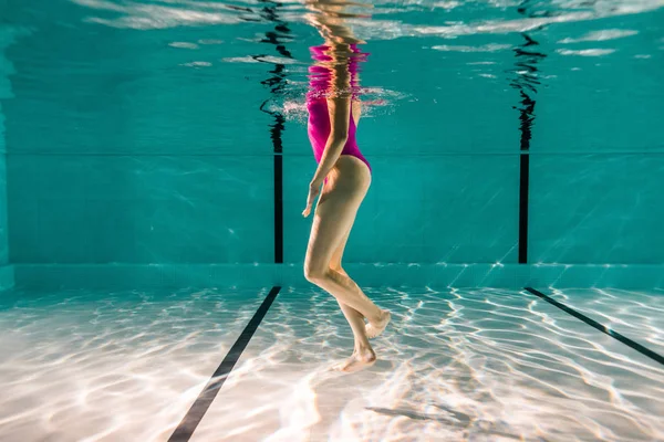 Vue recadrée de la femme nageant dans l'eau bleue dans la piscine — Photo de stock