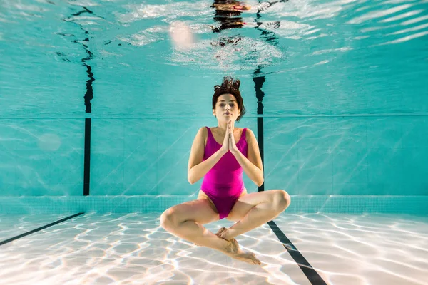 Приваблива жінка позує під водою в басейні — стокове фото