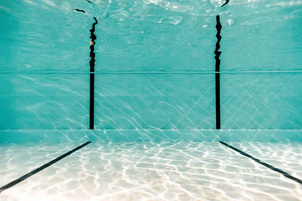 Bajo el agua en la piscina vacía con agua azul - foto de stock
