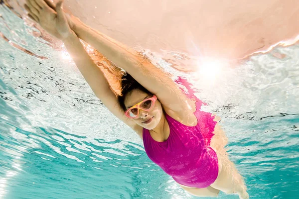 Mujer alegre en googles buceo bajo el agua - foto de stock