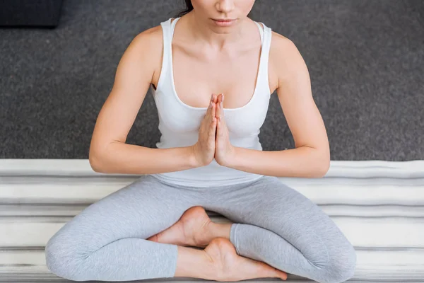 Abgeschnittene Ansicht einer meditierenden Frau in Lotuspose zu Hause — Stockfoto