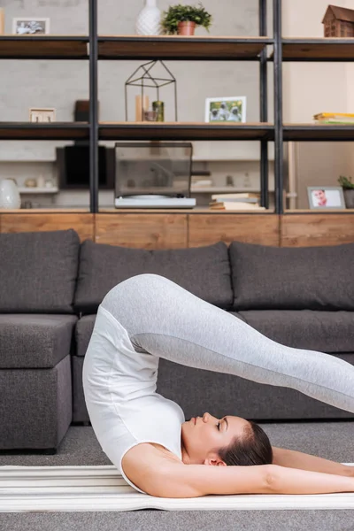 Woman practicing boat pose at home in living room — Stock Photo