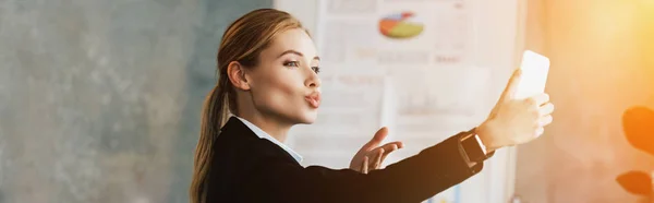 Beautiful young businesswoman taking selfie with duck face — Stock Photo