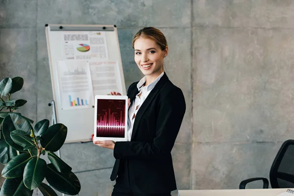 Lächelnde hübsche Geschäftsfrau mit digitalem Tablet mit Diagrammen und Diagrammen auf dem Bildschirm — Stockfoto