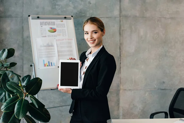 Femme d'affaires souriante tenant tablette numérique avec écran noir — Photo de stock