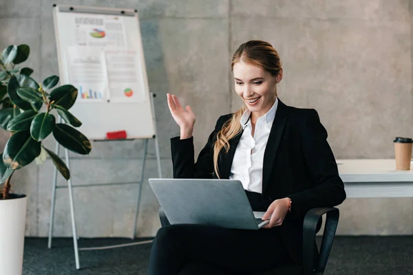 Smiling businesswoman looking at laptop and throws up hands — Stock Photo
