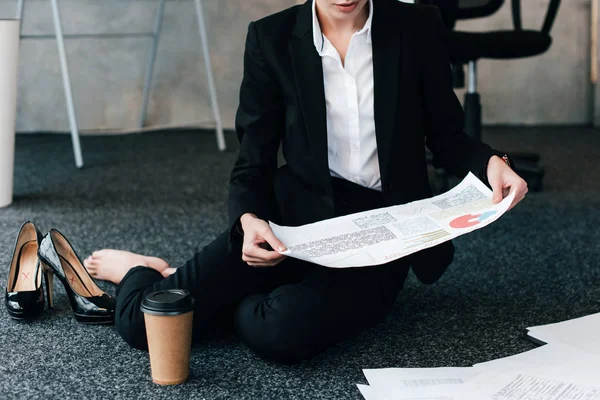 Vista cortada de empresária sentada no chão e documento de leitura — Fotografia de Stock
