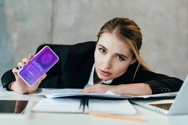 Foco seletivo de mulher de negócios na mesa de trabalho mostrando a tela do smartphone com compras — Fotografia de Stock