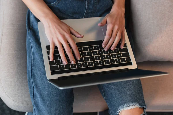 Vista recortada de las manos de mujer joven en el teclado del ordenador portátil - foto de stock