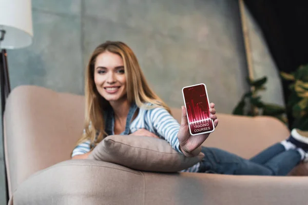 Messa a fuoco selettiva dello smartphone in mano della donna sul divano — Foto stock