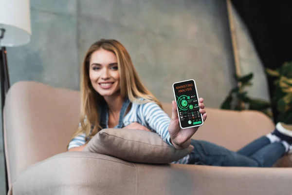 Selective focus of smartphone with marketing analysis app in hand of beautiful woman — Stock Photo