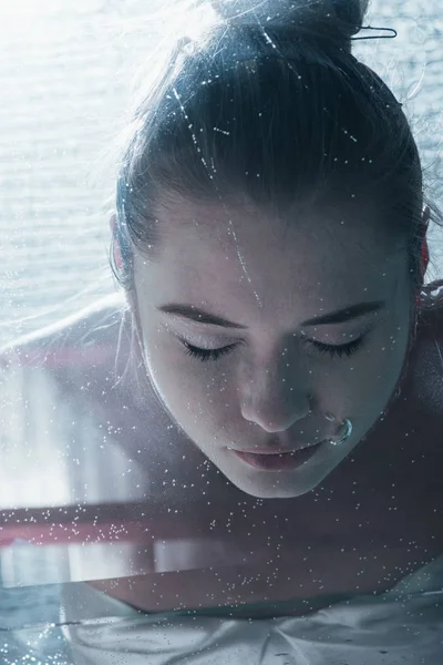 Close up of young woman diving underwater with closed eyes — Stock Photo