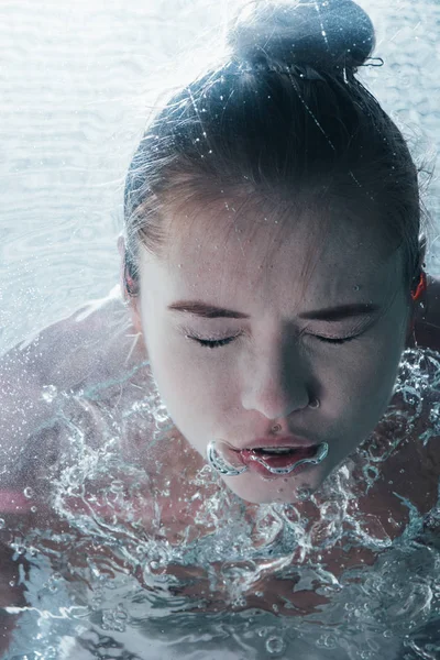 Крупным планом молодая женщина позирует под водой с закрытыми глазами — стоковое фото