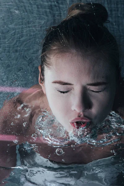 Крупним планом доросла дівчина позує під водою із закритими очима — стокове фото