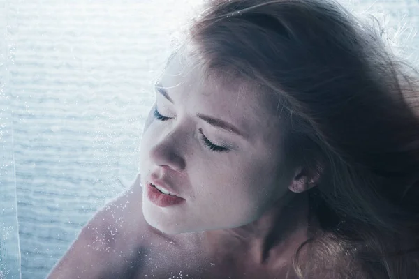 Крупним планом молода дівчина позує під водою із закритими очима — стокове фото