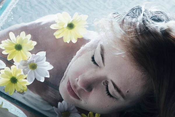 Крупним планом красива дівчина позує під водою з ромашками — стокове фото