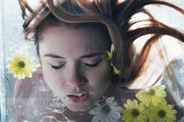 Primer plano de hermosa chica posando bajo el agua con flores - foto de stock