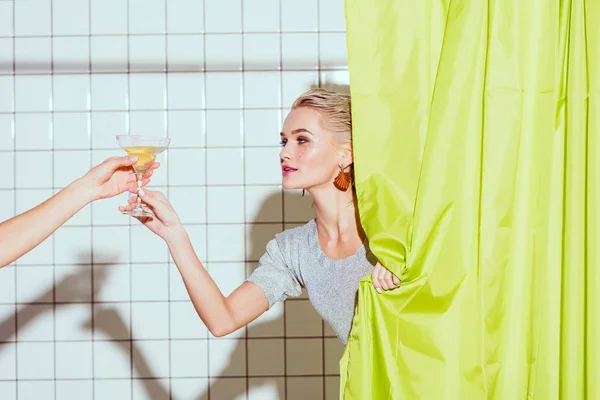 Beautiful young woman behind curtain taking cocktail in shower — Stock Photo
