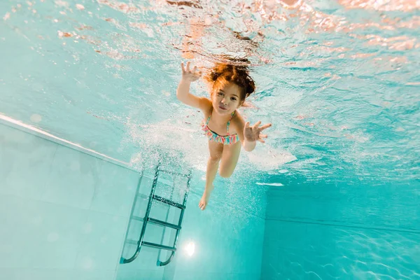 Mignon enfant nager sous l'eau bleue dans la piscine — Photo de stock