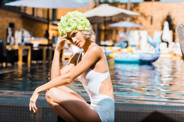 Attrayant pin up femme posant en maillot de bain blanc au bord de la piscine — Photo de stock