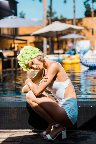 Молода жінка позує в білому купальнику біля басейну — стокове фото