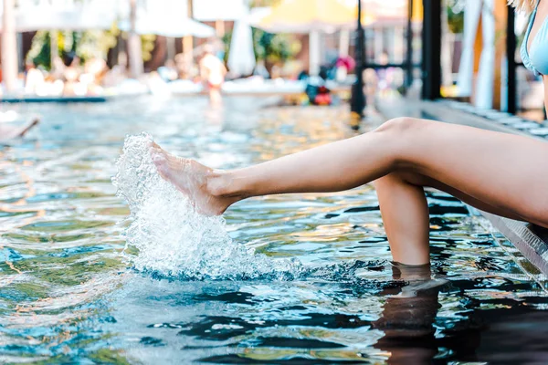 Vista recortada de la chica sentada cerca de la piscina - foto de stock