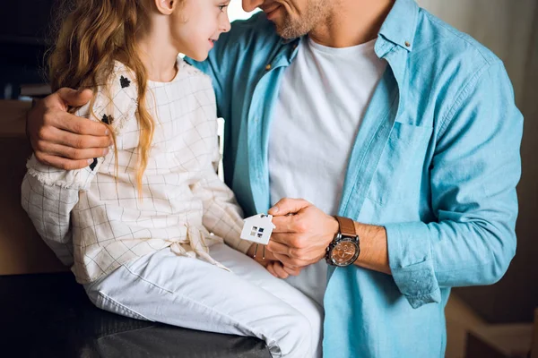 Cropped view of cute kid looking at father holding house shaped key chian — Stock Photo